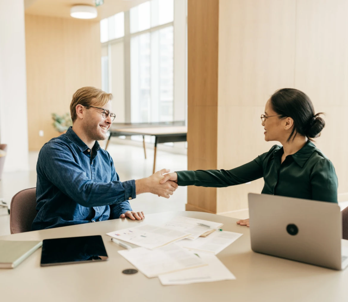 Colleagues shaking hands at desk